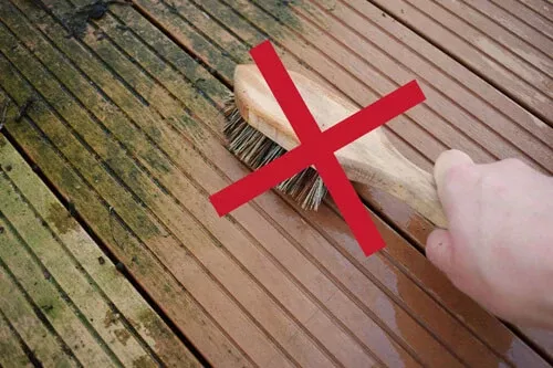 Eine Drahtbürste zum Grünbelag entfernen auf einem Terrassenboden